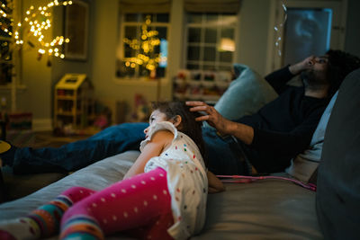 Father and daughter relaxing on couch and watching a movie