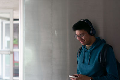 Side view of young man looking through window