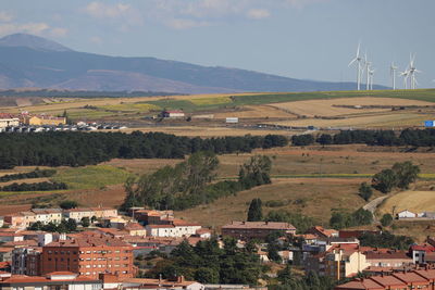 Landscape with wind turbines against mountains.