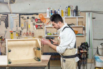 Side view of man working at shop