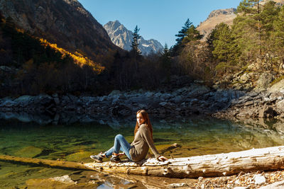 Nice girl traveler on red autumn lake