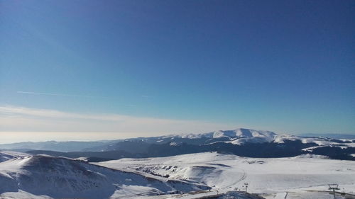 Scenic view of snowcapped mountains against blue sky