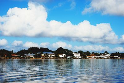 Scenic view of sea by buildings against sky