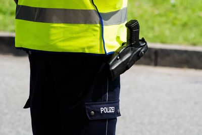 Midsection of police officer with handgun