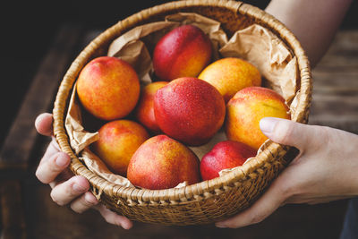 Close-up of hand holding strawberries in basket