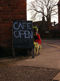 Open cafe sign by street in city