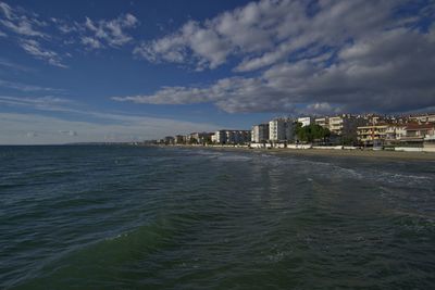 Scenic view of sea and cityscape against sky