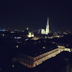 Illuminated cityscape against clear sky at night