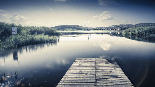 Pier over lake against sky