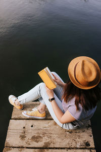 High angle view of woman sitting by water