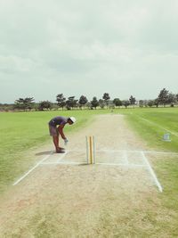 Full length of man skateboarding on field against sky