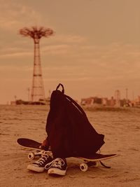 Close-up of shoes on skateboard and backpack outdoors