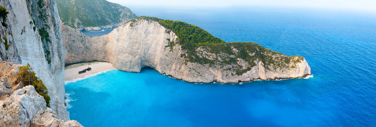 HIGH ANGLE VIEW OF ROCK FORMATIONS ON SEA