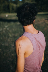 Rear view of shirtless man standing outdoors