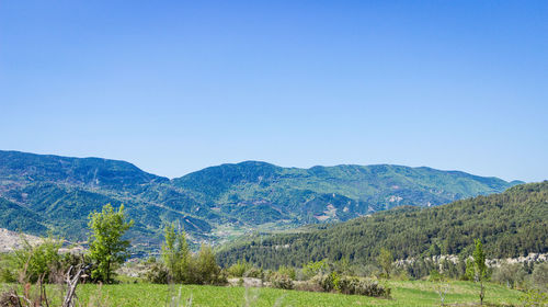 Scenic view of mountains against clear blue sky