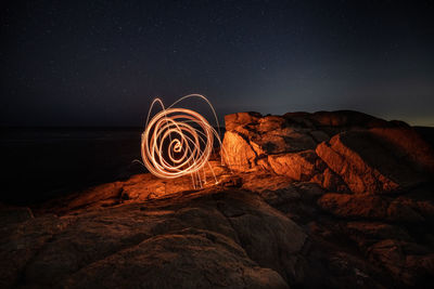 A spiral of fire against the dark night of the ocean