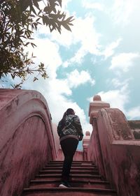 Rear view of woman standing on staircase