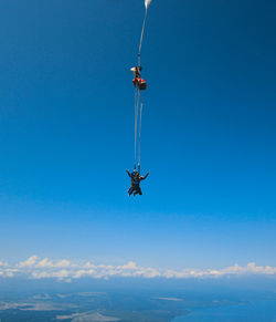 Low angle view of helicopter against clear blue sky