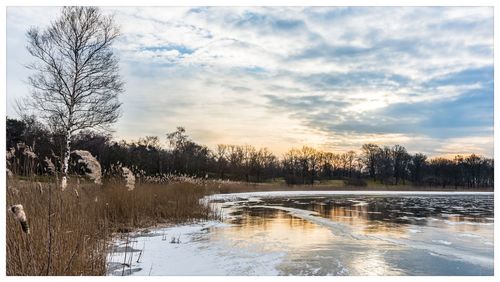 Scenic view of lake against sky during winter