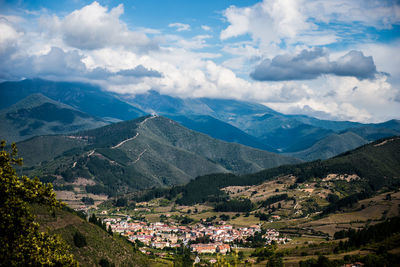 Aerial view of townscape and mountains against sky