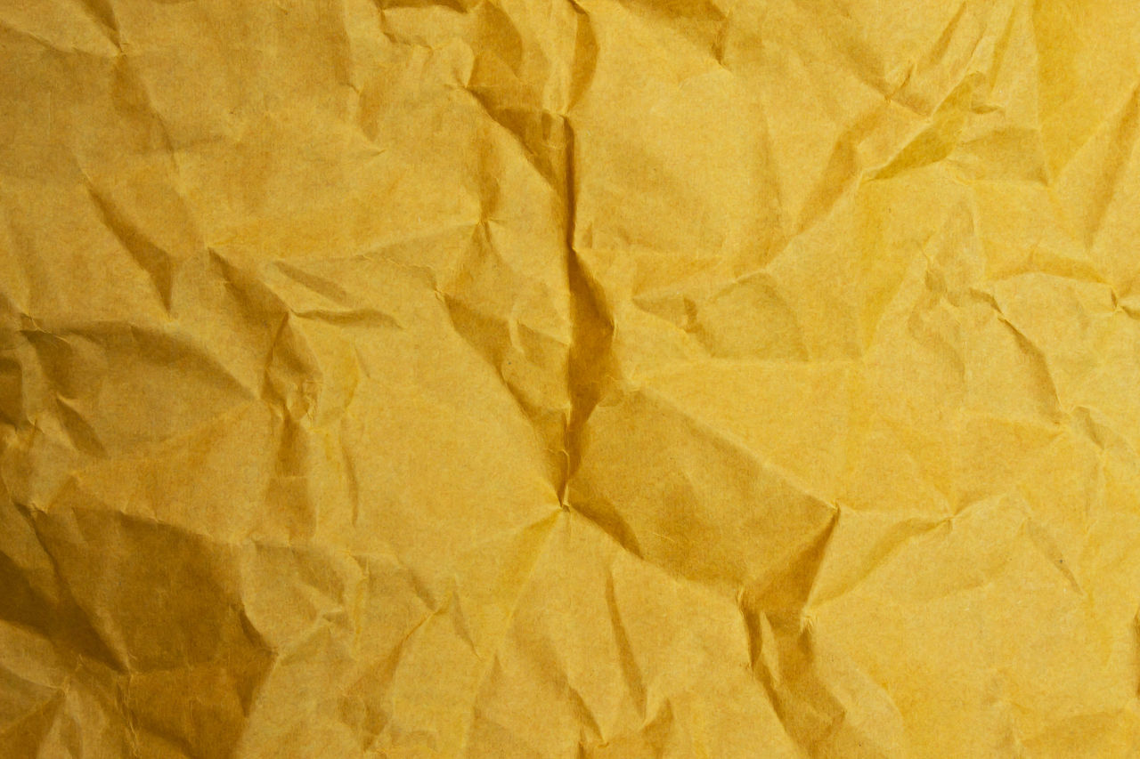 FULL FRAME SHOT OF YELLOW PAPER ON BED