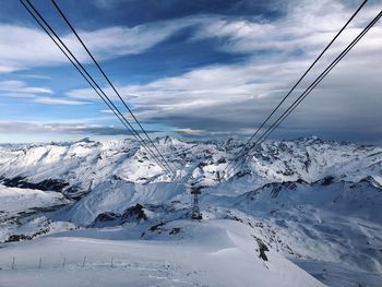 Scenic view of snowcapped french alps against blue skies and white clouds