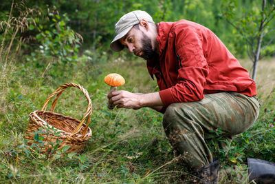 Rear view of man with pumpkins on field