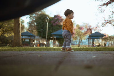 Full length of boy playing in public park