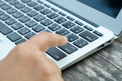 Close-up of person using laptop on table