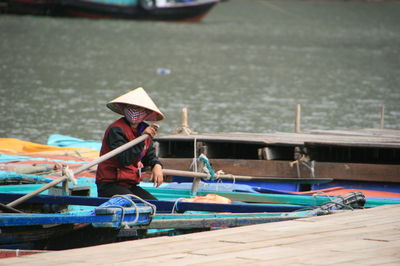 Man sitting in gondola by pier