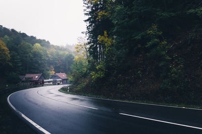 Road by trees against sky