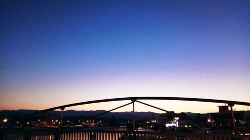 Illuminated cityscape against clear sky at sunset