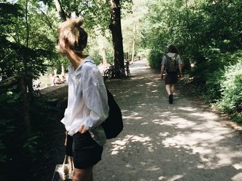 Rear view of woman standing by tree
