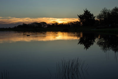 Scenic view of lake at sunset