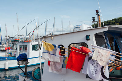 Boats moored at harbor against sky