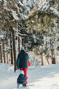 Mother and daughter on snow covered mountain