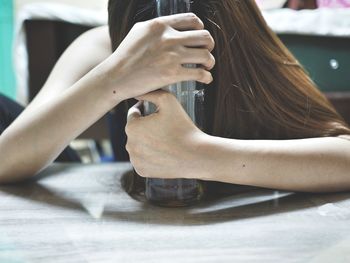 Close-up of depressed woman having alcohol at home