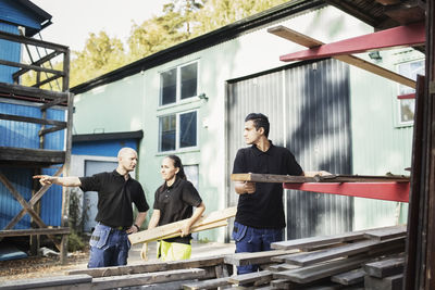 Carpentry teacher explaining students outside school