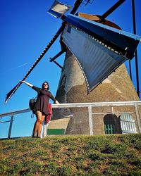Low angle view of woman standing against sky