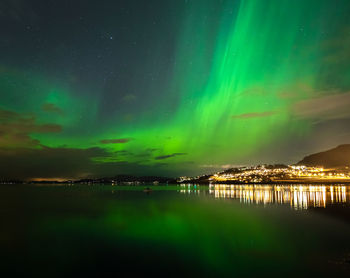 Scenic view of lake against aurora borealis at night