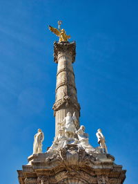 Low angle view of statue against blue sky