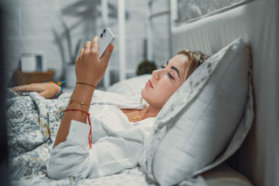 Low section of woman lying on bed at home