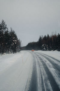 Snow covered road against clear sky