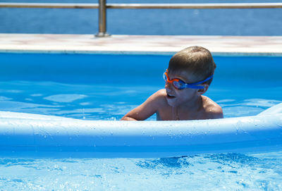 Portrait of shirtless boy swimming in pool