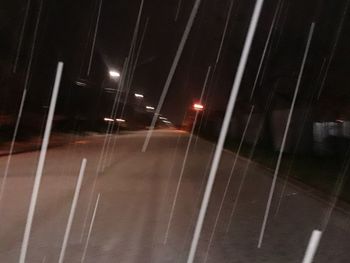 Illuminated street lights in city during rainy season at night