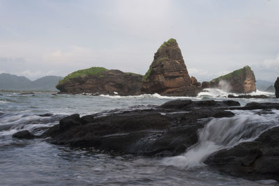 Rocks in sea against sky