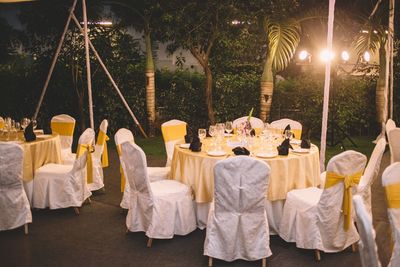 Dining tables arranged at backyard during dusk