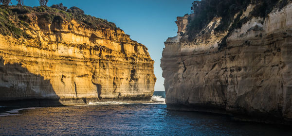 Rock formations by sea against sky