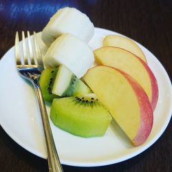 High angle view of chopped fruits in plate on table