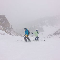 People skiing on mountain during foggy weather